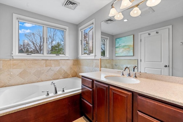 full bath with visible vents, a garden tub, and vanity