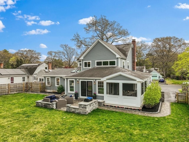 back of property with an outdoor hangout area, fence, a shingled roof, and a lawn