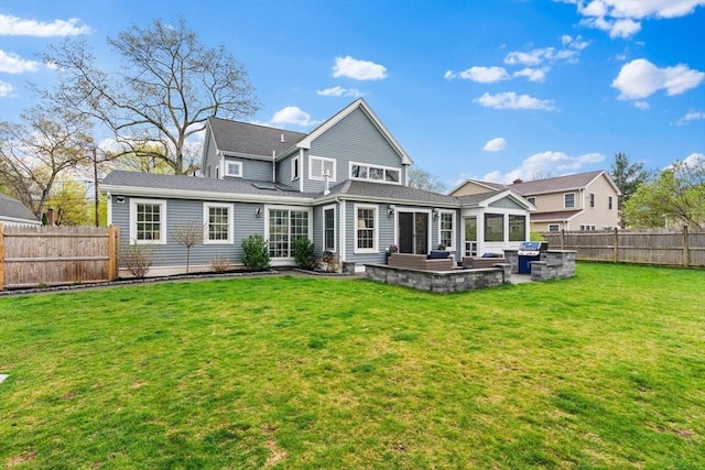 back of property with a patio, a fenced backyard, a yard, and a sunroom