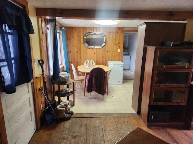 18 Central St, Ashburnham, MA 01430 - dining room featuring wood-type flooring, wooden walls, a textured ceiling, and washer / dryer
