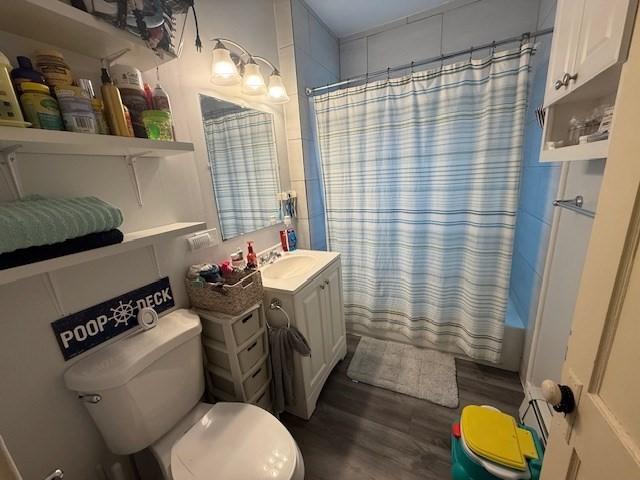 full bathroom with vanity, shower / tub combo, hardwood / wood-style flooring, and toilet