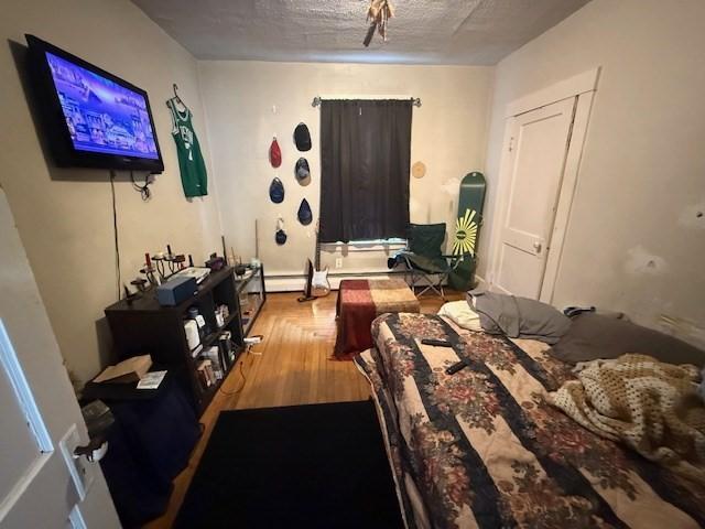 bedroom featuring hardwood / wood-style flooring and a textured ceiling