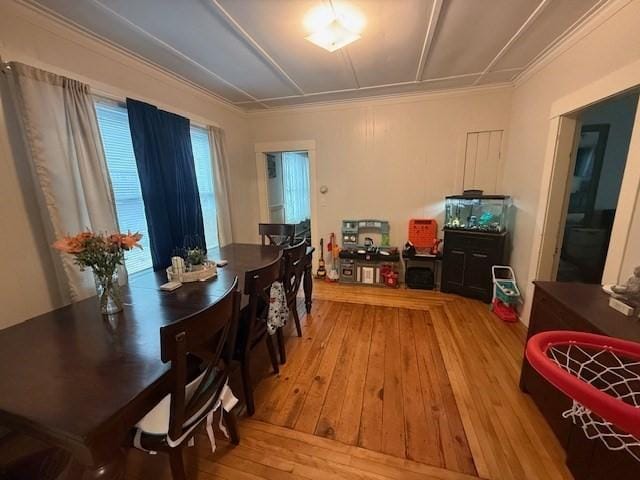 dining area with crown molding and light wood-type flooring