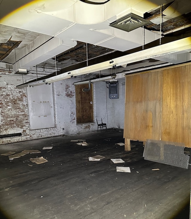 interior space featuring brick wall and dark hardwood / wood-style flooring