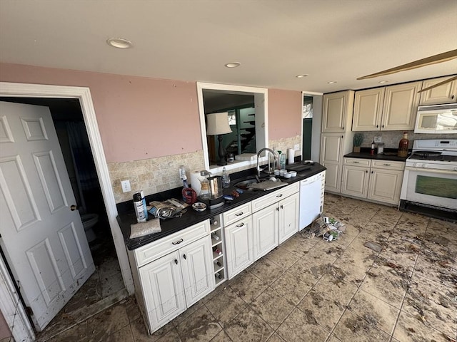 10 Nut Island Ave, Quincy, MA 02169 - kitchen featuring white appliances, dark countertops, decorative backsplash, a sink, and cream cabinets