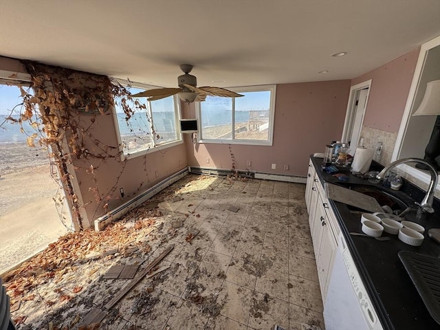 10 Nut Island Ave, Quincy, MA 02169 - kitchen featuring white cabinetry, a sink, dark countertops, a ceiling fan, and a baseboard radiator