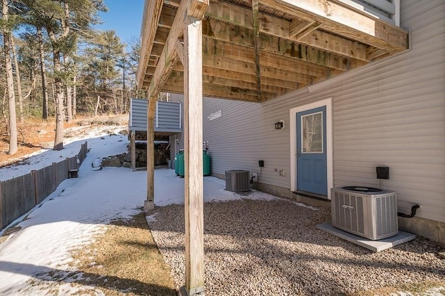 snow covered patio with central air condition unit