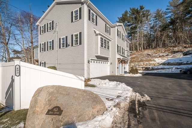 view of snow covered exterior featuring a garage