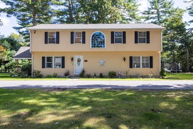 view of front of house featuring a trampoline and a front lawn