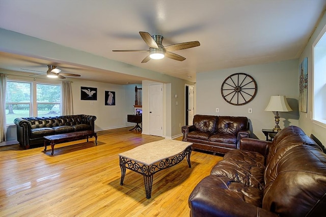 living room with ceiling fan and light hardwood / wood-style flooring