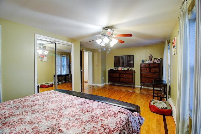 bedroom with ceiling fan, wood-type flooring, and a closet