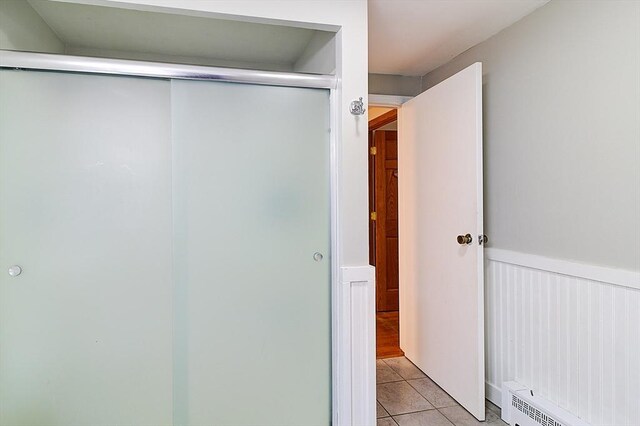 bathroom featuring a baseboard heating unit and tile patterned flooring