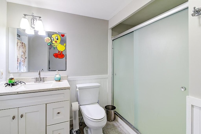 bathroom featuring toilet, tile patterned flooring, an enclosed shower, and vanity