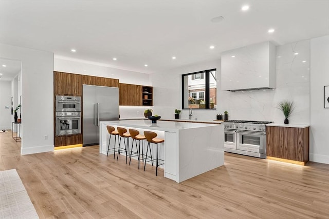 17 Prospect Hill Rd, Lexington, MA 02420 - kitchen featuring high quality appliances, modern cabinets, brown cabinets, a kitchen bar, and recessed lighting