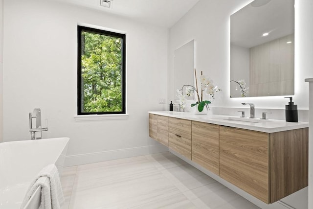17 Prospect Hill Rd, Lexington, MA 02420 - bathroom with a soaking tub, double vanity, baseboards, and tile patterned floors