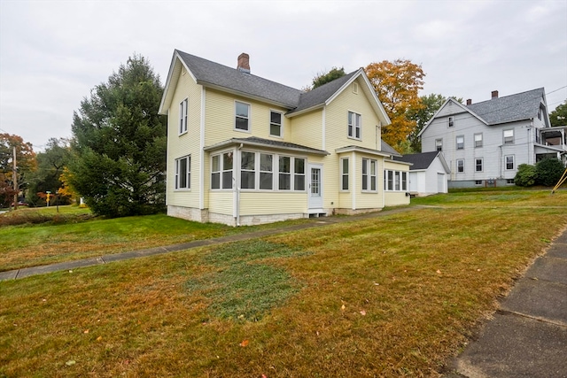 back of house with a sunroom and a lawn