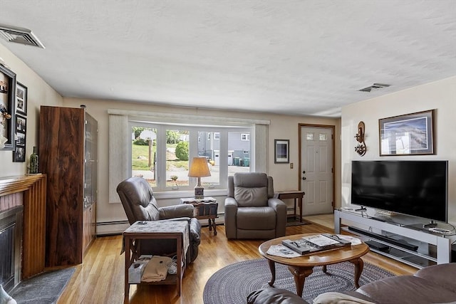8 Janis Ter, Woburn, MA 01801 - living room with baseboard heating, light wood finished floors, and a textured ceiling