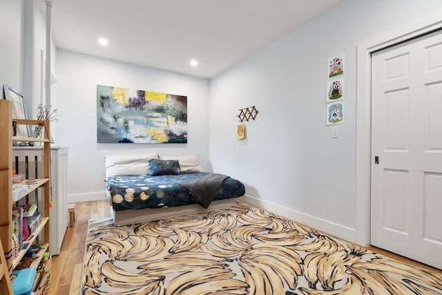 bedroom featuring baseboards, wood finished floors, and recessed lighting
