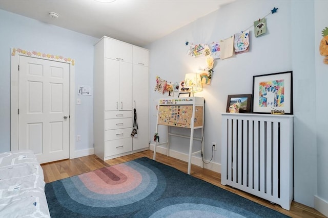 bedroom featuring wood finished floors and baseboards