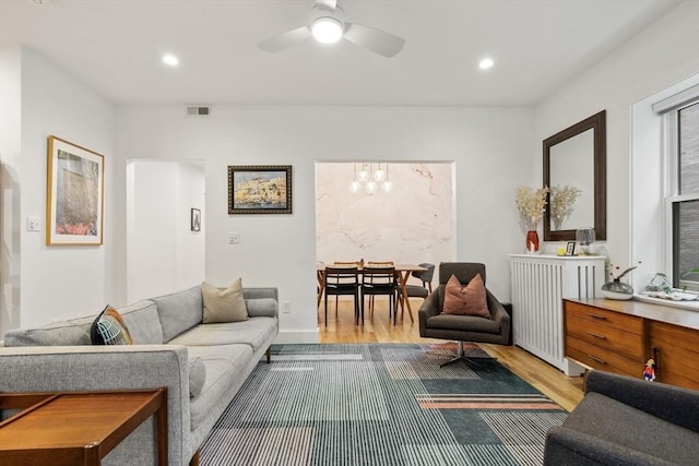living room with wood finished floors, ceiling fan, a chandelier, and recessed lighting