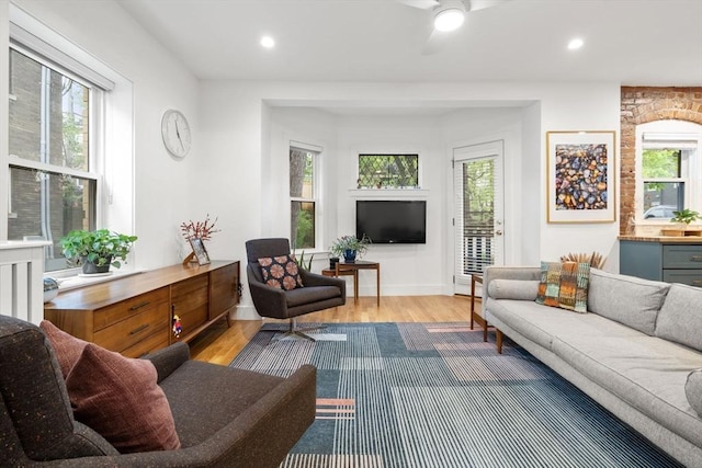 living area with healthy amount of natural light, wood finished floors, ceiling fan, and recessed lighting