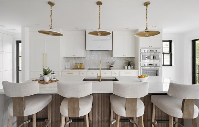 361 Walden Unit 361, Cambridge, MA 02138 - kitchen with stainless steel double oven, tasteful backsplash, light countertops, white cabinetry, and a kitchen island with sink