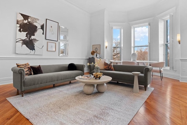 living area featuring wood-type flooring and ornamental molding