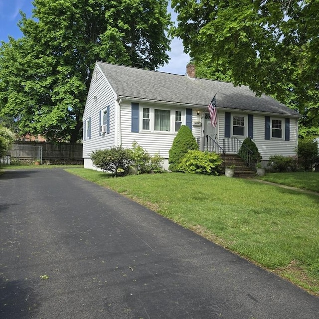 view of front of house with a chimney, asphalt driveway, and roof with shingles
