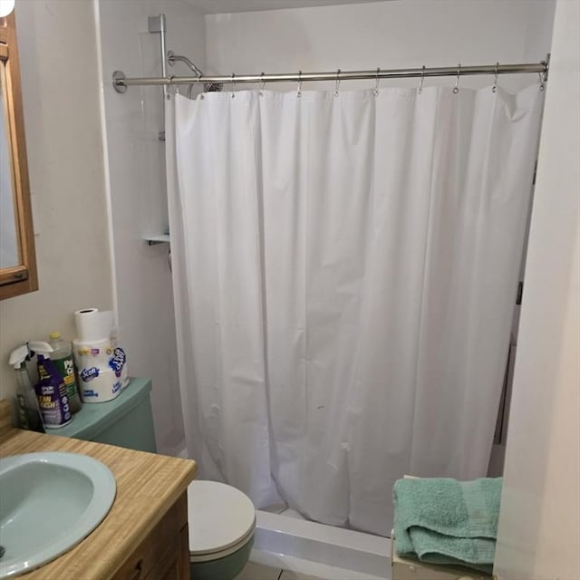 bathroom featuring toilet, a stall shower, and vanity