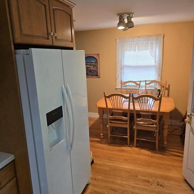 dining room with light wood finished floors and baseboards