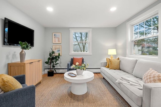 living area featuring a baseboard heating unit, plenty of natural light, and recessed lighting