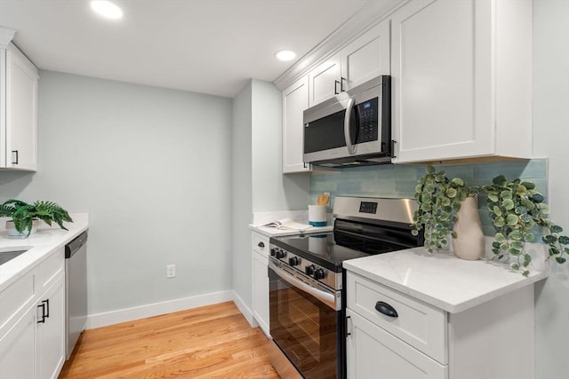 kitchen with white cabinets, light wood-style floors, backsplash, and stainless steel appliances