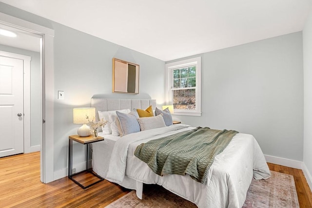 bedroom with baseboards and wood finished floors