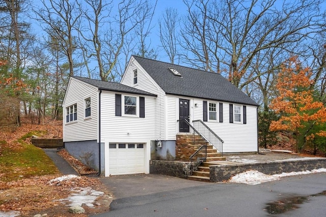 view of front of property featuring aphalt driveway, an attached garage, and roof with shingles