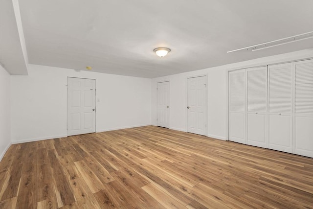 172 Bishop Dr Unit 172, Framingham, MA 01702 - unfurnished bedroom featuring wood finished floors, multiple closets, and baseboards