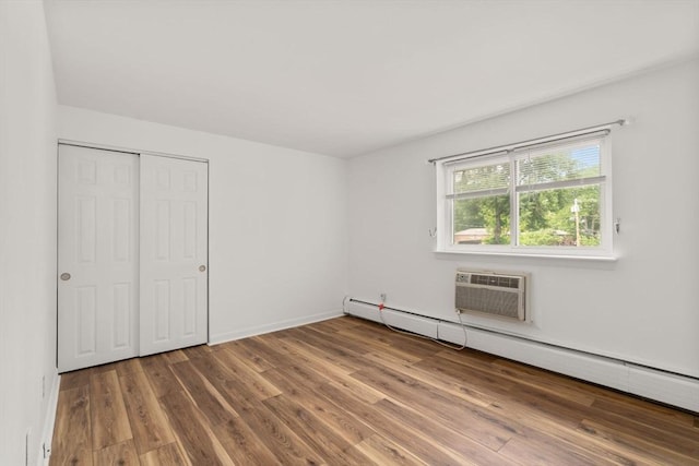172 Bishop Dr Unit 172, Framingham, MA 01702 - unfurnished bedroom featuring wood finished floors, baseboard heating, a closet, and a wall unit AC