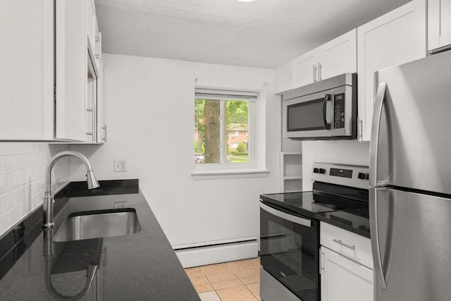 172 Bishop Dr Unit 172, Framingham, MA 01702 - kitchen featuring appliances with stainless steel finishes, a baseboard heating unit, a sink, white cabinetry, and backsplash