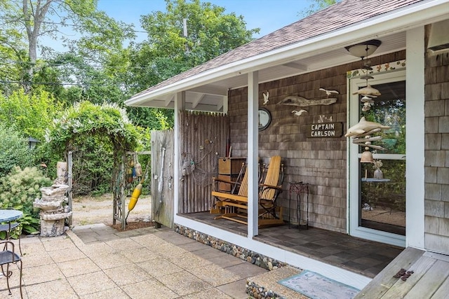 137 Rock Harbor Rd Unit 4, Orleans, MA 02653 - doorway to property featuring roof with shingles and a patio area