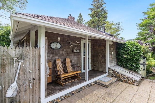 137 Rock Harbor Rd Unit 4, Orleans, MA 02653 - view of exterior entry with a chimney and roof with shingles
