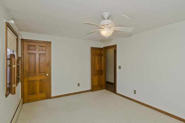 unfurnished bedroom with a baseboard radiator, light colored carpet, and ceiling fan