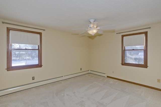 carpeted empty room featuring ceiling fan and baseboard heating