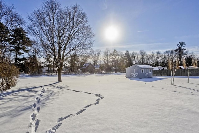 yard layered in snow featuring a storage unit