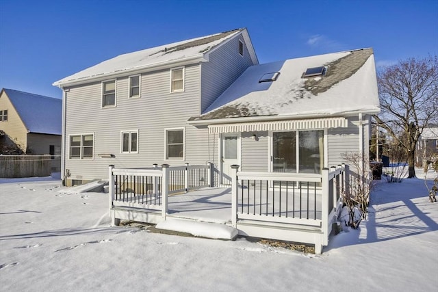 snow covered back of property featuring a porch