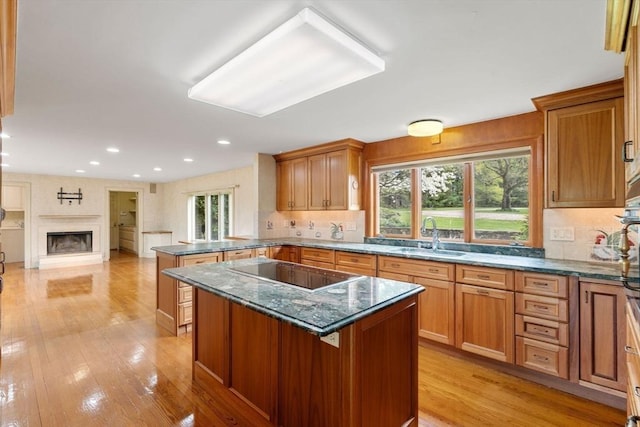 38 Bullard St, Sherborn, MA 01770 - kitchen featuring a sink, black electric cooktop, a peninsula, decorative backsplash, and light wood finished floors