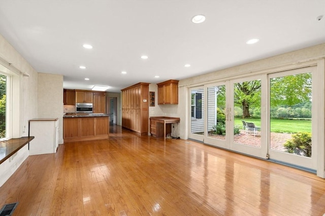 38 Bullard St, Sherborn, MA 01770 - kitchen with oven, brown cabinetry, light wood-type flooring, recessed lighting, and dark countertops