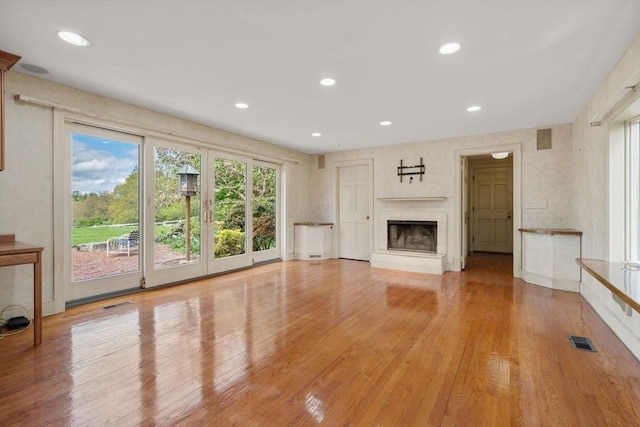 38 Bullard St, Sherborn, MA 01770 - unfurnished living room with recessed lighting, light wood-style flooring, and a fireplace with raised hearth