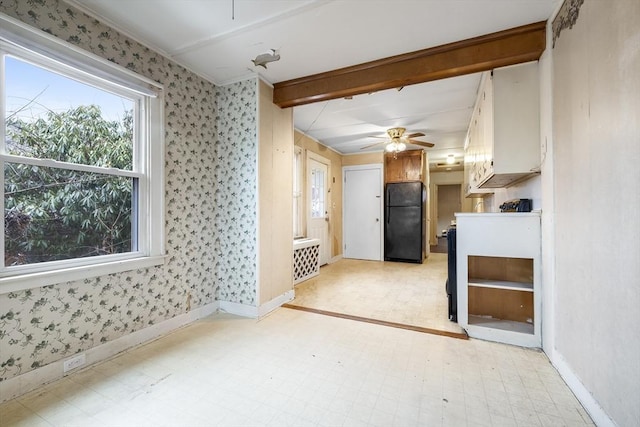 interior space with a ceiling fan, baseboards, light floors, and wallpapered walls