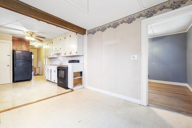 kitchen featuring light floors, light countertops, freestanding refrigerator, white cabinets, and range with electric cooktop