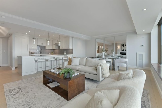 living room with ornamental molding and light wood-type flooring