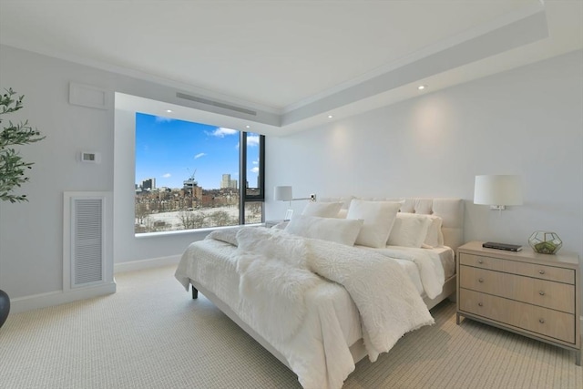 carpeted bedroom featuring crown molding and a tray ceiling